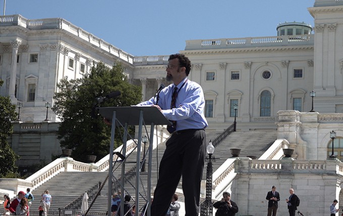 Nurse Keith Carlson stands at a podium in front of the Supreme Court