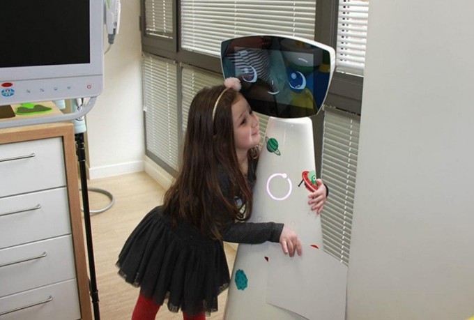 Young female patient is hugging a robot that has a smile on its screen