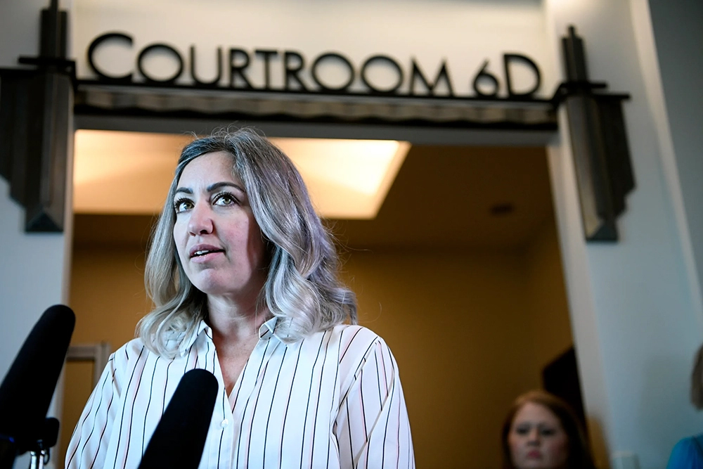 RaDonda Vaught stands in front of a courtroom, talking in front of a microphone