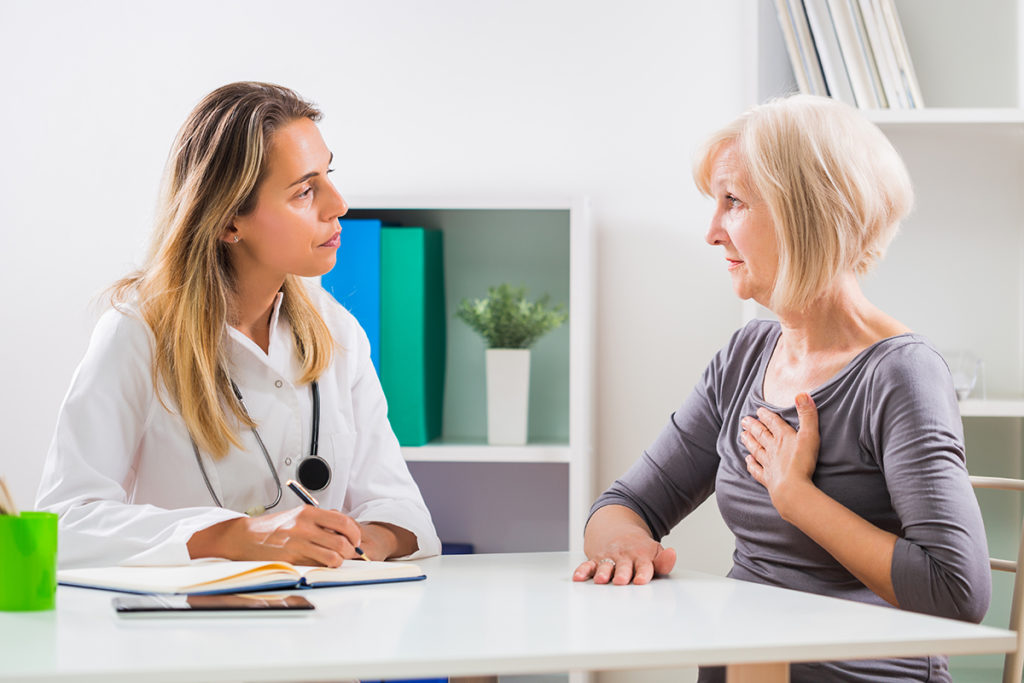 Patient telling nurse practitioner about pain in her chest