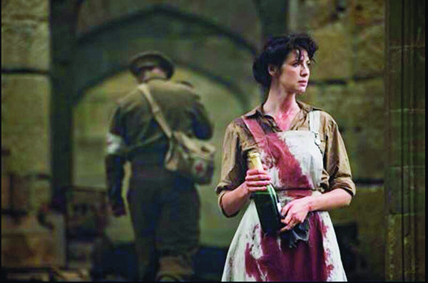 RN Claire from Outlander covered in blood and holding a bottle