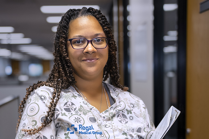 Sabrina Keys from Regal Medical Group in scrubs next to a patient room