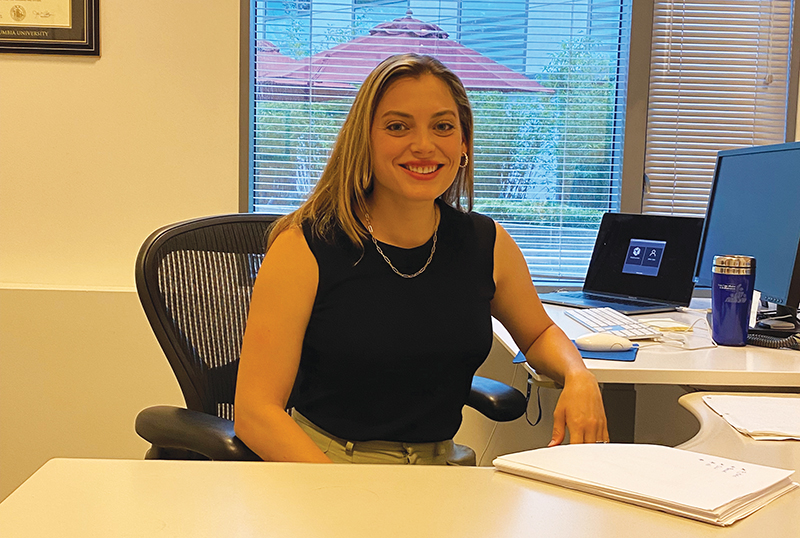 Catherine Cohen, nurse researcher with RAND corporation, sits at her desk smiling.